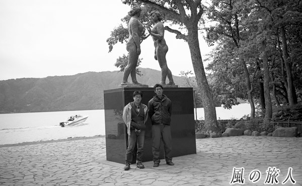 十和田湖畔の像の前で後輩と記念撮影した写真