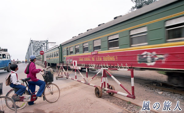 ベトナム　手動踏切を通過する列車の写真