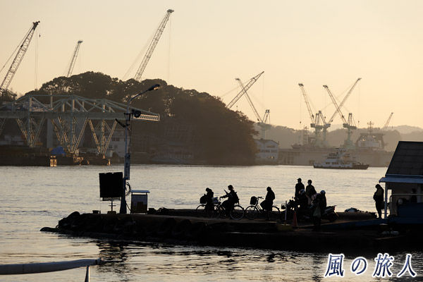 尾道　夕暮れの桟橋で渡船を待つ人々の写真