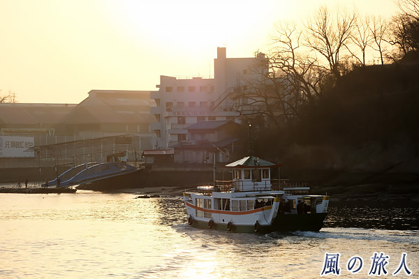 冬の尾道　朝日に向かって進む渡船の写真