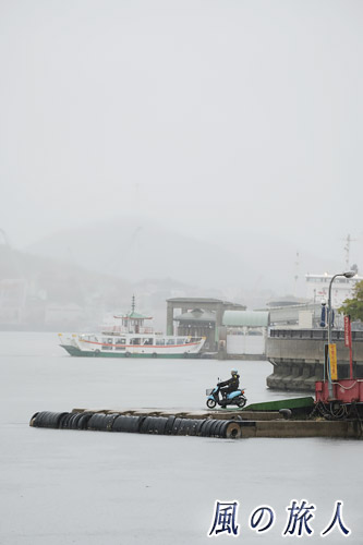 尾道　雨の中、船の到着を待つスクーターの写真