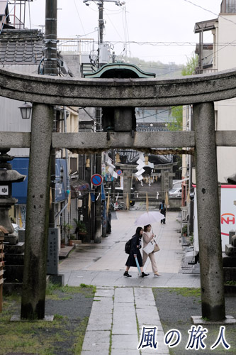 尾道　亀山八幡宮　鳥居前を通過していく仲良く傘に納まる親子の写真